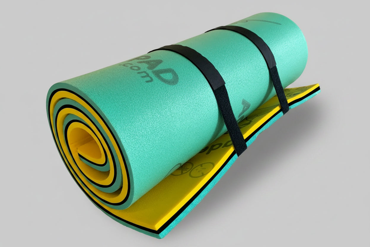 A rolled-up water toy, resembling a lily pad, in green and yellow colors, secured with a black strap and a drawstring.